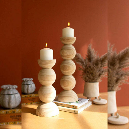 Wooden candle holder with a candle on a table against a red wall