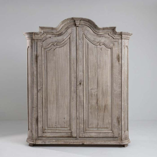 Vintage-style wooden wardrobe with intricate carvings on a white background