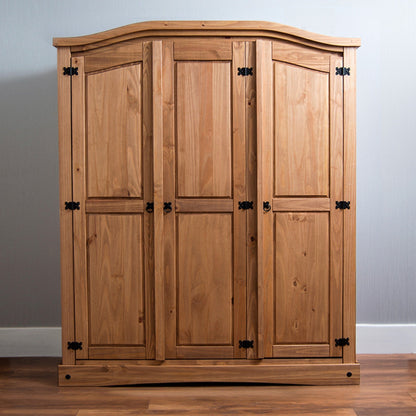 A wooden armoire with three doors and iron hardware, displayed in a room setting.