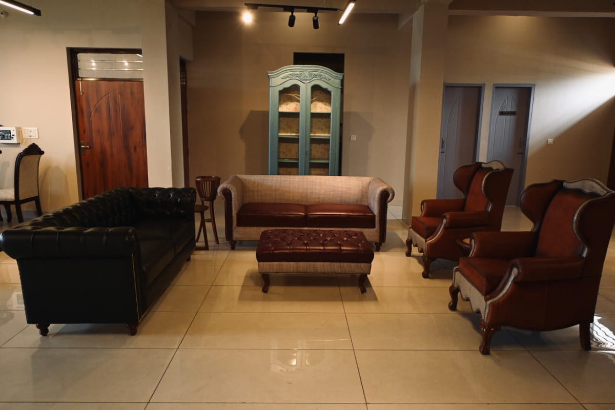 Living room with black sofa, brown leather chairs, and a green cabinet.