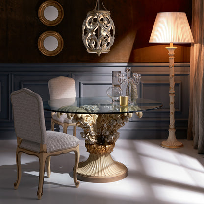 Dining room with a decorative table and chairs, featuring a lamp and wall art.