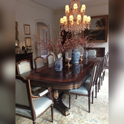 Dining room with a large wooden table, chairs, and a chandelier.