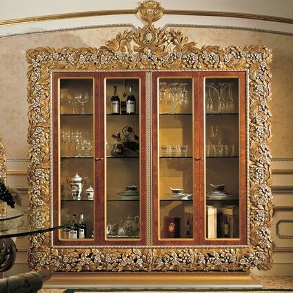 Decorative wooden cabinet with gold embellishments in an elegant room.