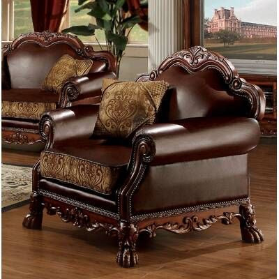 Brown leather armchair with ornate carvings in a room with large windows.