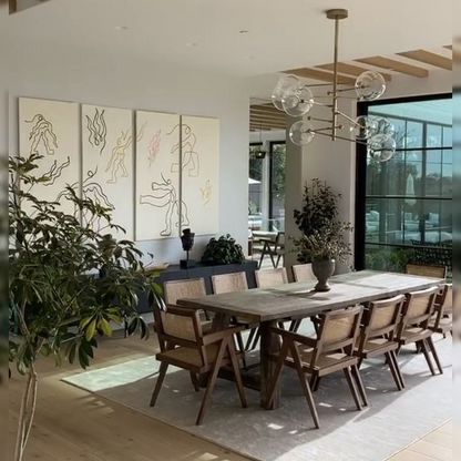 Modern dining room with wooden table and chairs, large windows, and abstract wall art.