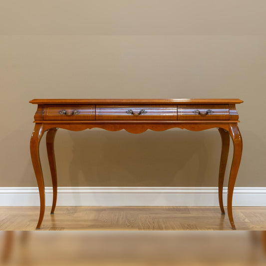 Wooden console table with curved legs against a beige wall.