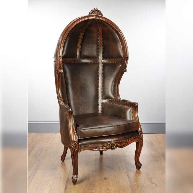 Decorative brown leather chair with wooden frame on a light wood floor.