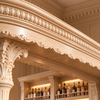 Close-up of an ornate carved wooden bar console with decorative columns and a scalloped apron, shown in a warm beige tone with blurred bottles in the background.