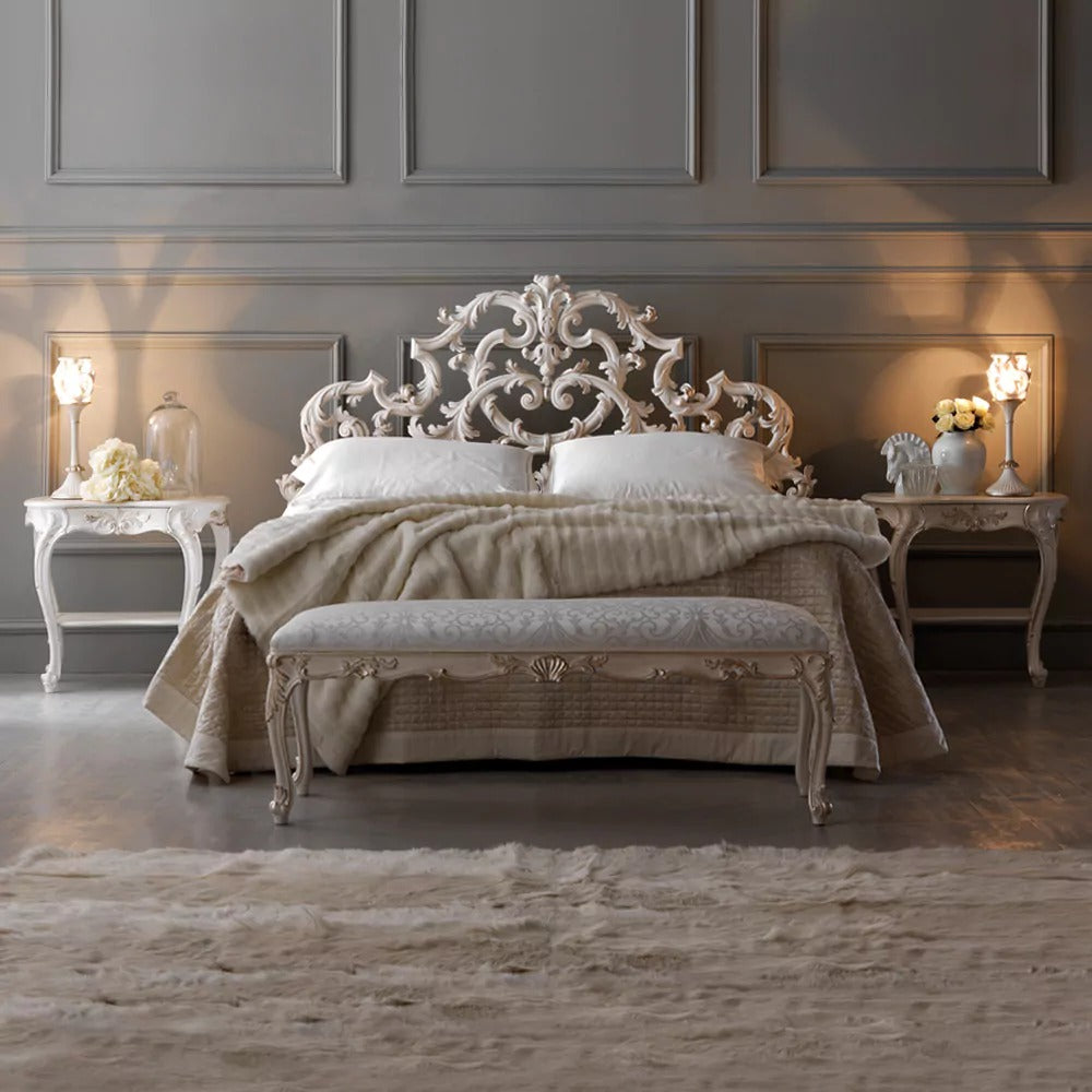Decorative bed with intricate headboard in a room with gray walls and marble floor.