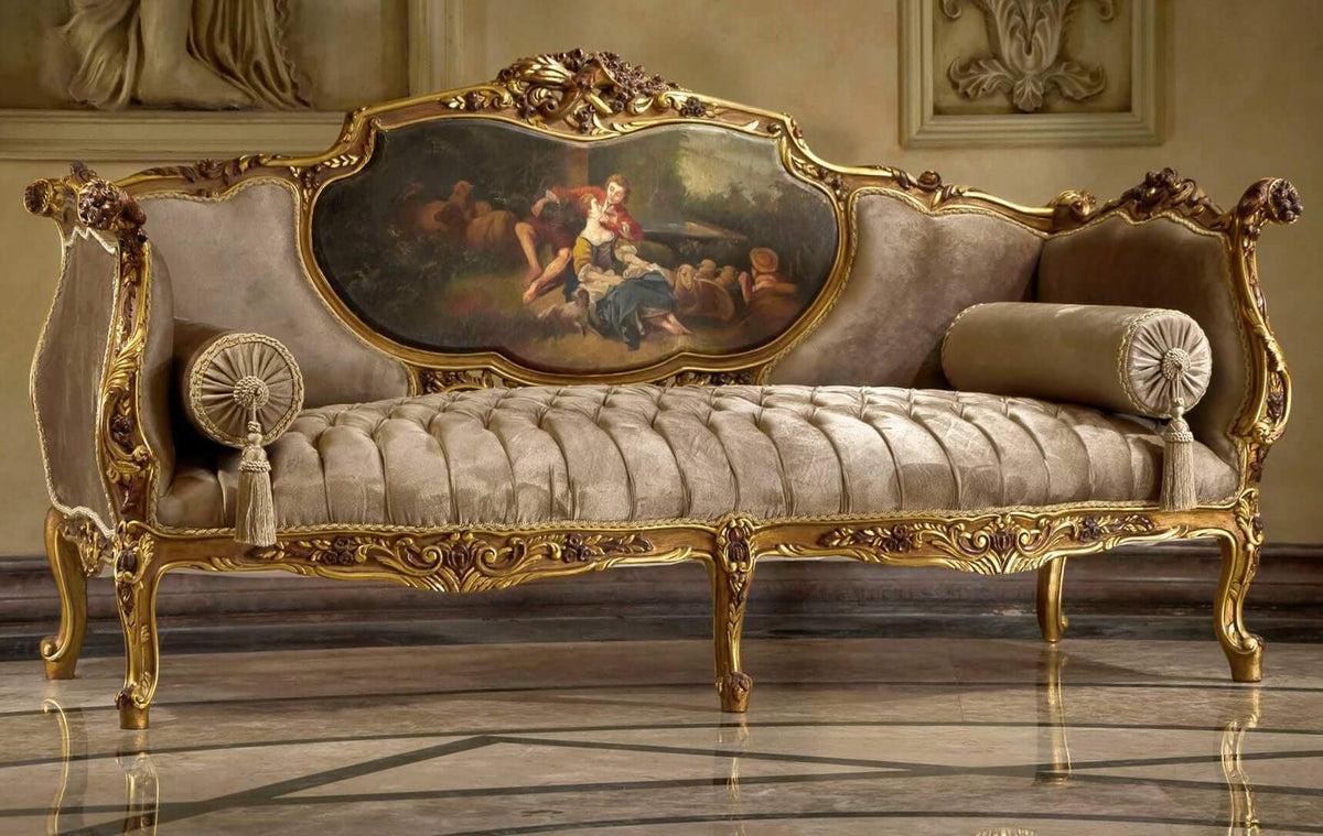 An ornate living room set featuring a sofa with plush beige upholstery and gold detailed carvings, accompanied by two matching chairs and a double-decker centre table with a vintage-inspired wallpaper finish on the lower tier and a sleek glass top on the upper tier.