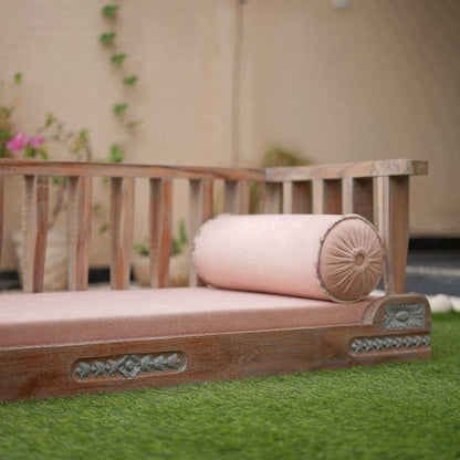 Wooden bench with pink cushion on grass