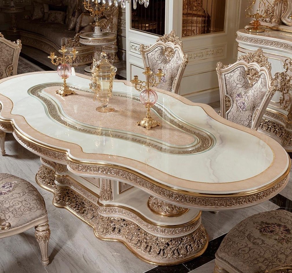Decorative dining table with ornate chairs in a luxurious room.