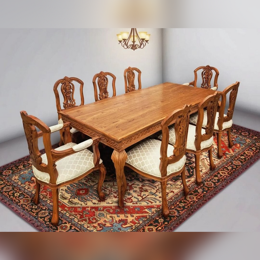 Wooden dining table with chairs on a patterned rug in a room with a chandelier.