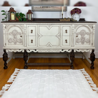 Decorative white sideboard with intricate carvings on a wooden floor.