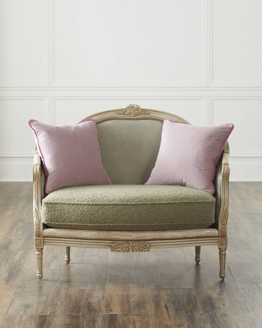 Vintage-style chair with pink cushions against a white paneled wall.