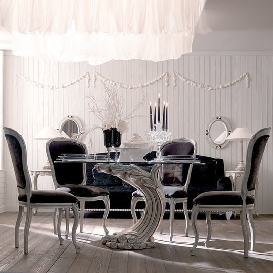 Elegant dining room with a glass table and black chairs.