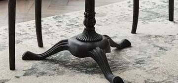 Close-up of a decorative metal table base on a marble floor