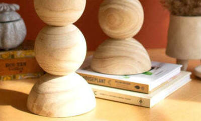 Stack of wooden spherical objects on books with a warm-toned background