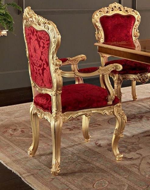 Decorative chairs with red velvet seats and gold frames on a patterned rug.