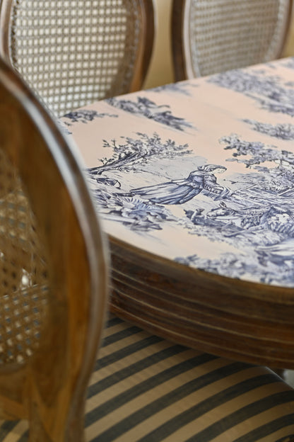 Stack of blue and white patterned plates on a table with wicker chairs.