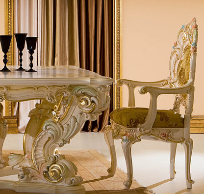 Decorative table and chair set with intricate designs in a room with gold curtains.