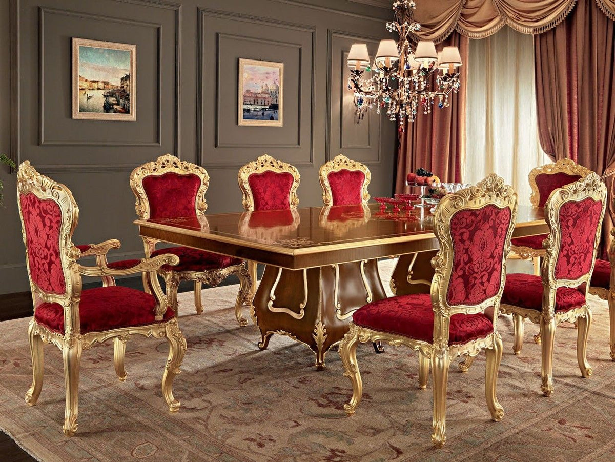 Dining room with a gold table and red chairs in a luxurious setting.