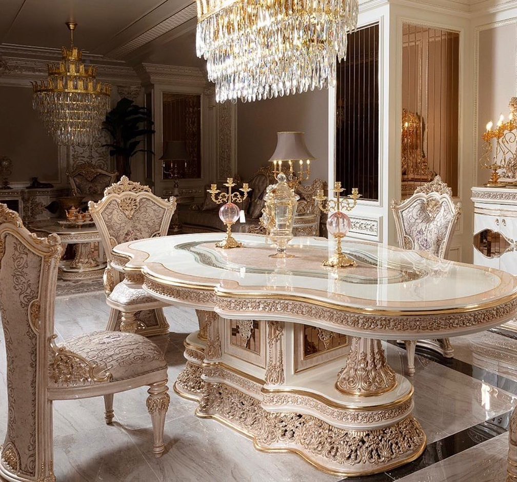 Luxurious dining room with ornate table and chairs, crystal chandeliers, and decorative elements.