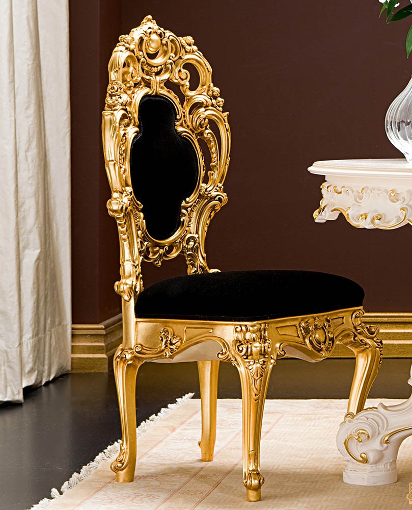 Decorative gold chair with black cushion against a brown wall