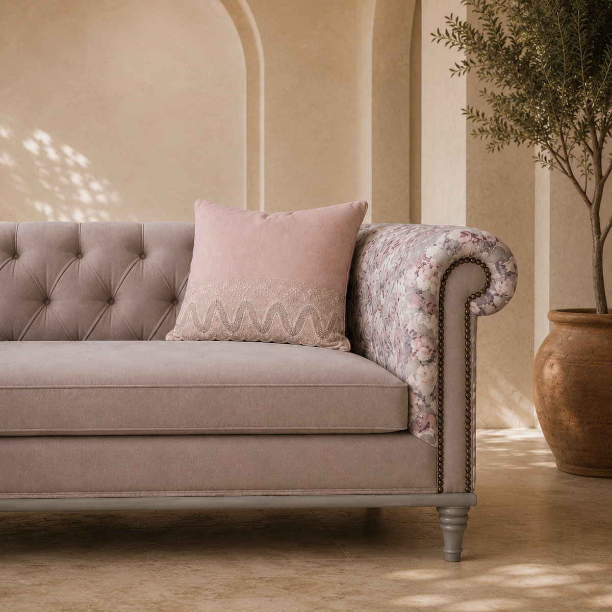 Beige sofa with a pink pillow in a room with beige walls and a plant.