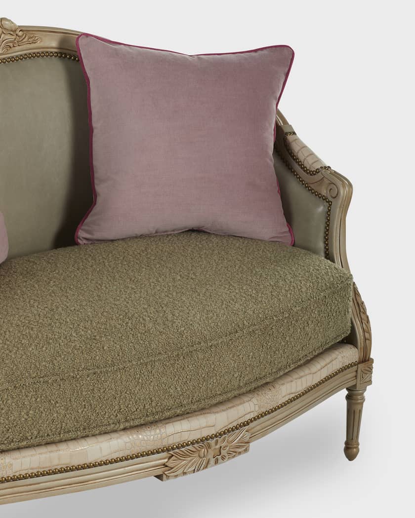 Vintage-style sofa with ornate detailing and a pink cushion on a white background