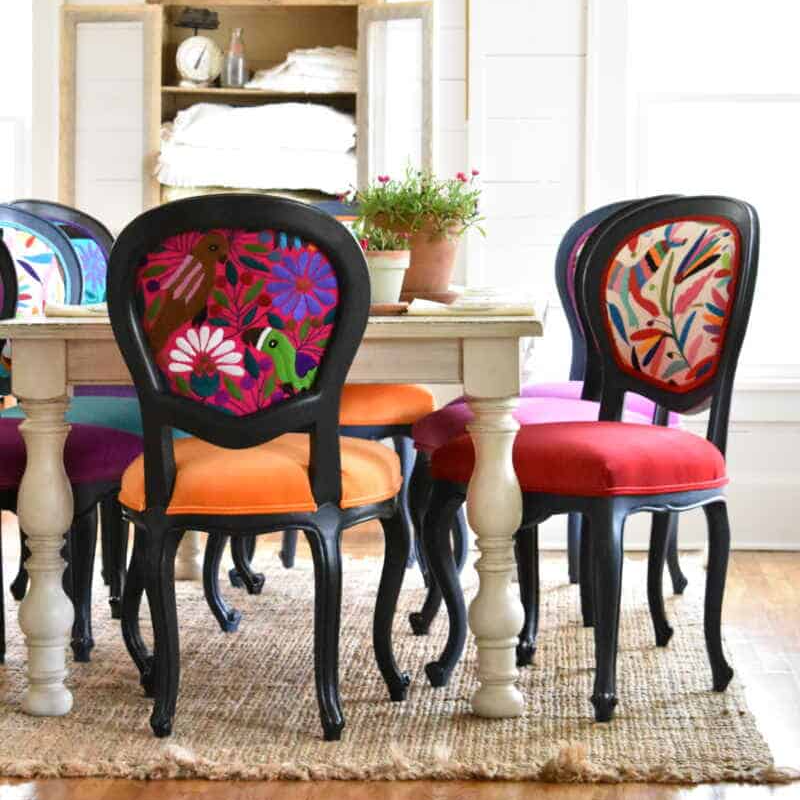 Colorful chairs with floral patterns around a dining table in a home setting.
