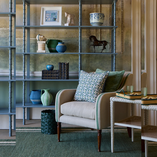 Living room with a bookshelf, armchair, and decorative items.