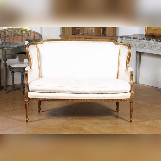 An ivory upholstered three-seater sofa with a classic design, featuring wooden legs and a plush backrest.