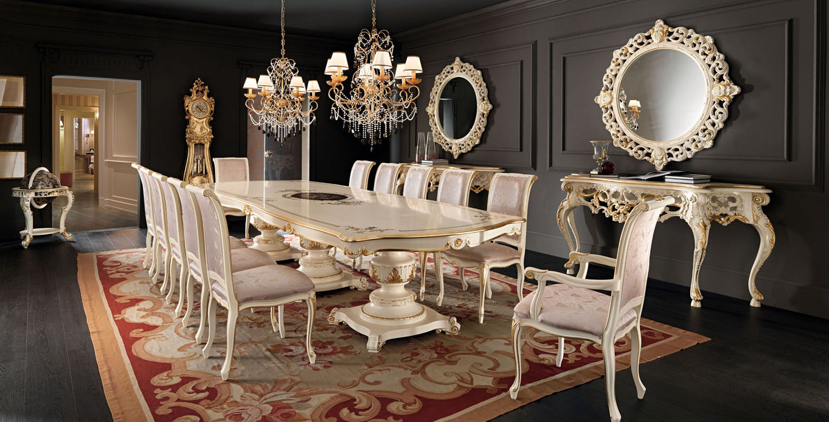 Elegant dining room with a large ornate table and chairs, chandeliers, and decorative mirrors.