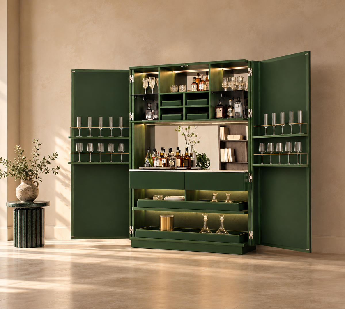 A large dark green bar cabinet with both doors open, styled in a warm beige room. The cabinet is fully stocked with bottles, glasses, and bar accessories, and features built-in shelving, a mirror, and glass holders on the side panels.