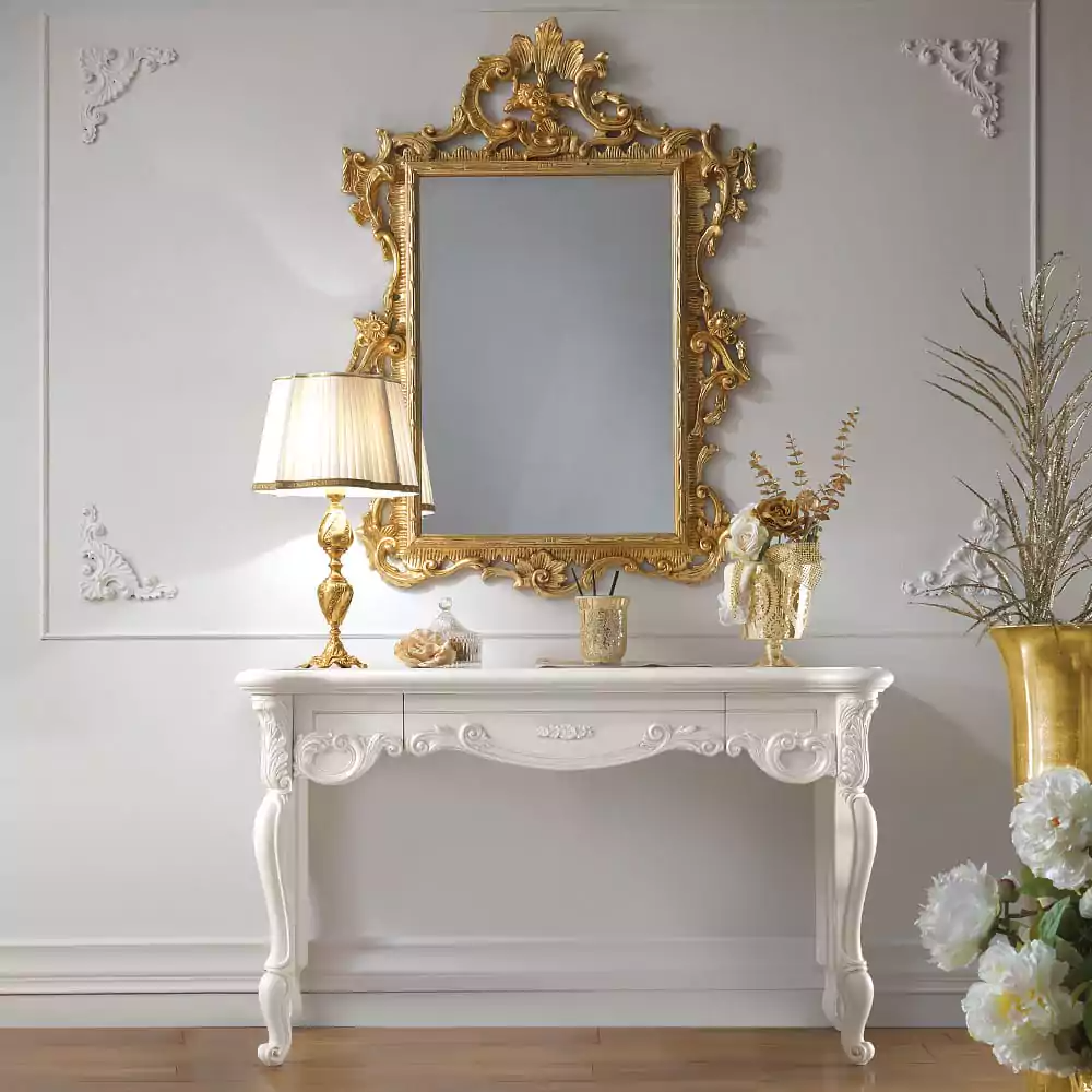 An ivory carved wall mounted console set with intricate carvings, complemented by a grand gold mirror, a lamp, and decorative items.